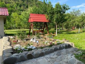 a garden with a gazebo in a yard at Casa Cărbunaru in Tîrgu Ocna