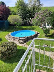 a swimming pool in a yard with a stone fence at Hotel Gut Landscheid in Burscheid