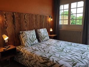 1 dormitorio con 1 cama, 2 lámparas y ventana en Auberge du Bois de l'étang - Motel les Tilleuls, en Peyrat-le-Château