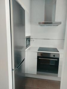 een kleine keuken met een roestvrijstalen koelkast bij VIVIENDA BOCA DO RIO- Carnota in Carnota