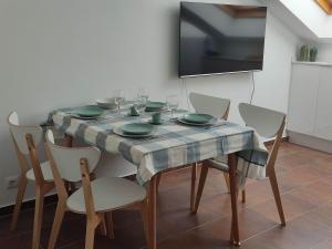 een eettafel met stoelen en een tv bij VIVIENDA BOCA DO RIO- Carnota in Carnota