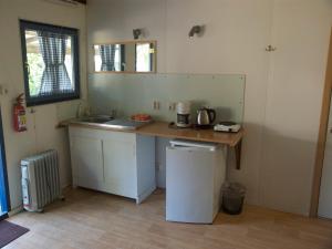 una piccola cucina con bancone e lavandino di Holiday home OSSA Basecamp a Sint Odiliënberg