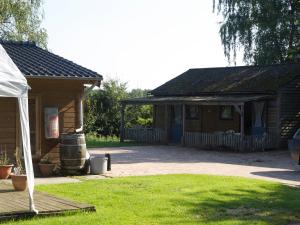 Cabaña de madera con porche y patio en Holiday home OSSA Basecamp, en Sint Odiliënberg