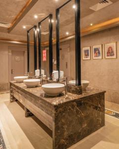 a bathroom with two sinks and a large mirror at AMC Royal Hotel & Spa in Hurghada