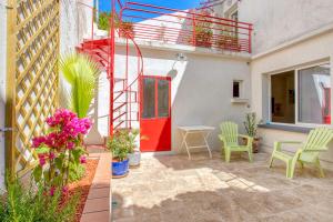 a patio with a red door and a table and chairs at Gite AVIGNON BOUGAINVILLIER in Avignon