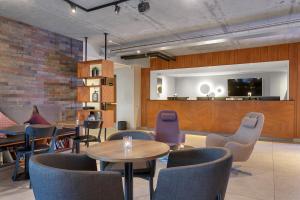a restaurant with tables and chairs and a flat screen tv at Konvin Hotel by Reykjavik Keflavik Airport in Keflavík