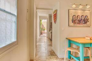 a hallway with a blue table and a window at Gite AVIGNON BOUGAINVILLIER in Avignon