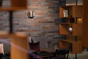 a room with a brick wall and a table with pillows at Konvin Hotel by Reykjavik Keflavik Airport in Keflavík
