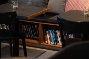 a coffee table with two chairs and a book shelf with books at Konvin Hotel by Reykjavik Keflavik Airport in Keflavík