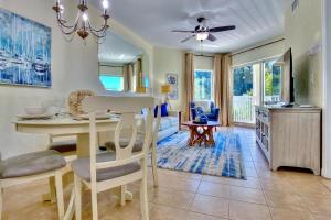 a living room with a table and a living room with a couch at Sunset Vistas Condo 203S in St Pete Beach