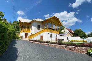 uma grande casa amarela e branca com uma entrada em Segesdy Villa em Balatonalmádi