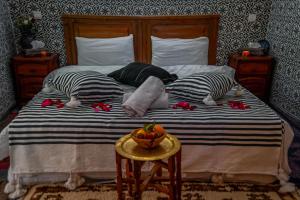 Una cama con dos almohadas y un bol de fruta. en Riad Dar Mamouni, en Marrakech