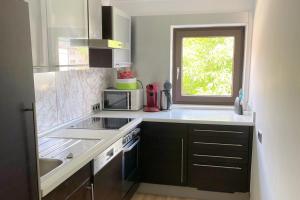 a kitchen with a sink and a microwave and a window at Areit Apartments - Low Budget in Zell am See