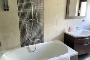a bathroom with a bath tub and a sink at Areit Apartments - Low Budget in Zell am See
