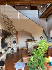 a large living room with a stone fireplace at L'Orée des Mages - Ma maison de vacances in Saint-Julien-de-Cassagnas