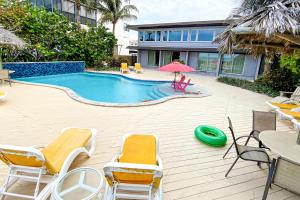 - une piscine avec des chaises et un frisbee vert dans l'établissement Sugar Sands A, à St. Pete Beach