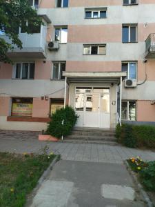 un edificio con una puerta blanca y escaleras delante en Apartament max. confort en Tulcea