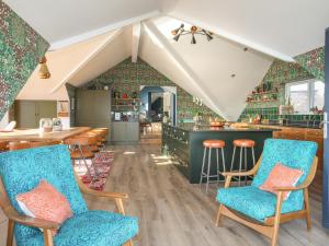 a living room with blue chairs and a bar at Glan Towyn in Holyhead