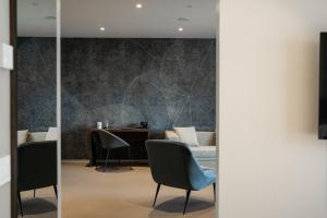 a waiting room with chairs and a table at Elitis House - Suite & Spa in Nova Milanese