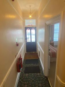 a hallway with a blue door and a fire hydrant at Landguard Lodge Guest House in Southampton