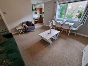 a living room with a couch and a table at Swan Path Retreat - 2 Bedroom Apartment in Heybridge