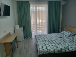 - une chambre avec un lit et une fenêtre avec des rideaux verts dans l'établissement Апартаменти Віланж, à Polyana