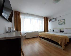 a bedroom with a bed and a large window at 4 Seasons Apartments in Bistriţa
