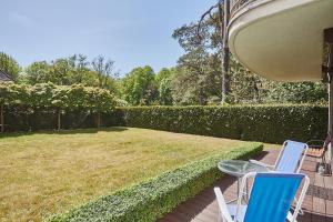 patio z 2 krzesłami i trawnikiem w obiekcie Apartamenty Świnoujście - Apartament kapitański Rezydencja Żeromskiego w Świnoujściu