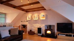 a living room with a fireplace and a tv at Tighnabruaich Duplex Apartment - Sea Views in Tighnabruaich