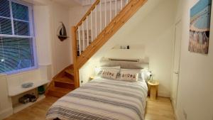 1 dormitorio con cama y escalera en Tighnabruaich Duplex Apartment - Sea Views, en Tighnabruaich