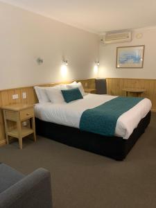 a hotel room with a large bed and a couch at LaTrobe Motel Morwell in Morwell