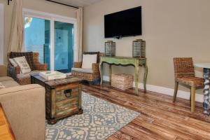 a living room with a couch and a tv on the wall at Bungalow Beach Place 2 in Clearwater Beach