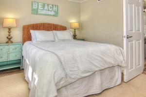 - une chambre dotée d'un grand lit avec des draps et des oreillers blancs dans l'établissement Bungalow Beach Place 2, à Clearwater Beach