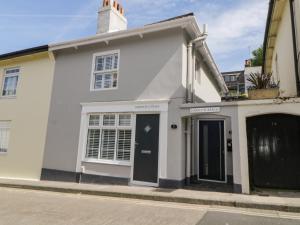 a white house with a black door on a street at Harbour Reach in Torquay