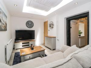 a living room with a couch and a tv at Harbour Reach in Torquay