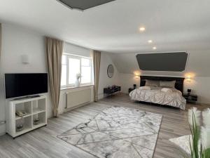 a bedroom with a bed and a flat screen tv at Hotel Rosenheim in Schwentinental