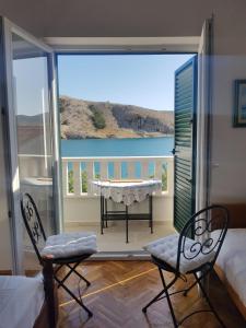 a room with a balcony with a table and chairs at Family Apartment Miluna in Metajna