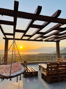 una veranda con altalena con il tramonto sullo sfondo di Sunset Apartments a Kotor (Cattaro)