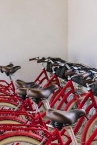 a row of red bikes parked next to each other at Oustau Camarguen Hôtel & Spa in Le Grau-du-Roi