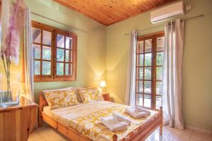 a bedroom with a bed and two windows at Anastasia Apartments in Koroni