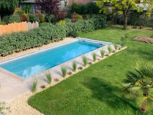 a swimming pool in the middle of a yard at Chambre d'hôtes de Verdigné Piscine chauffée Parking Wifi in Le Mans +28 photos