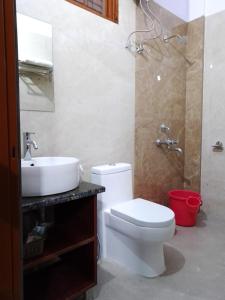 a bathroom with a toilet and a sink at Harela Inn in Chamoli