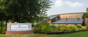 a sign in front of a building with a garden at Sandford Springs Hotel and Golf Club in Kingsclere