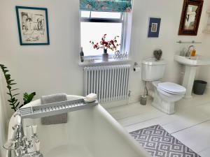 a bathroom with a tub and a toilet and a sink at Lovely 3 bed house in the heart of Cheltenham in Cheltenham +28 photos