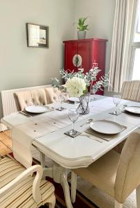 una mesa de comedor con platos y flores. en Stunning 3 bed house in the heart of Cheltenham en Cheltenham