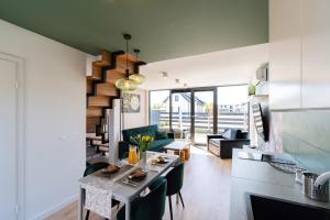 a kitchen and living room with a table and chairs at Domki - Bursztynova 13 in Łeba