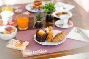 una mesa cubierta con platos de desayuno y zumo de naranja en B&B Isabella, en Milano Marittima