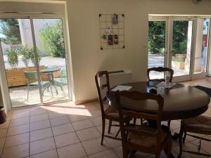 jadalnia ze stołem i krzesłami oraz przesuwnymi szklanymi drzwiami w obiekcie Castel Mireio w mieście Cairanne
