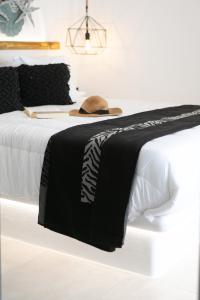 a black and white bed with a hat on it at Villa Oceana in Mikri Vigla