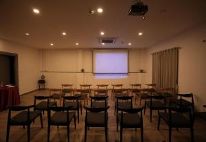 a room with a bunch of chairs and a projection screen at GRAND GANPAT in Vellore